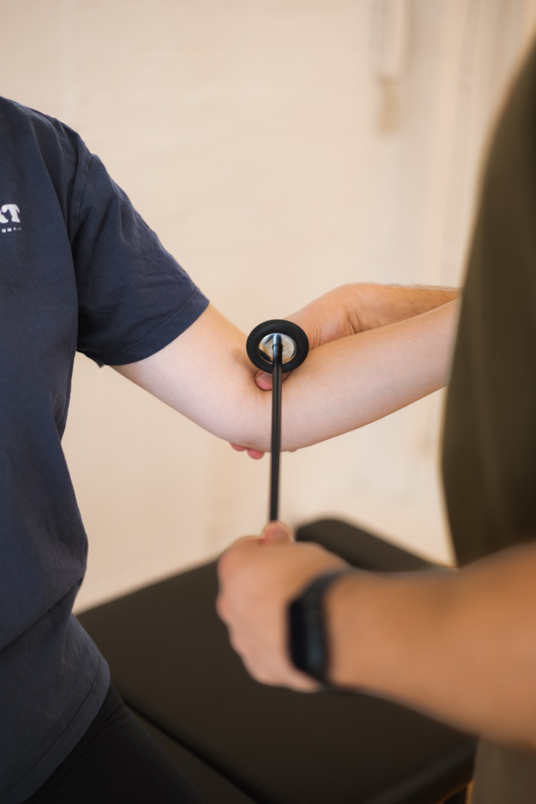 A close-up of Tom testing a patient's arm reflexes