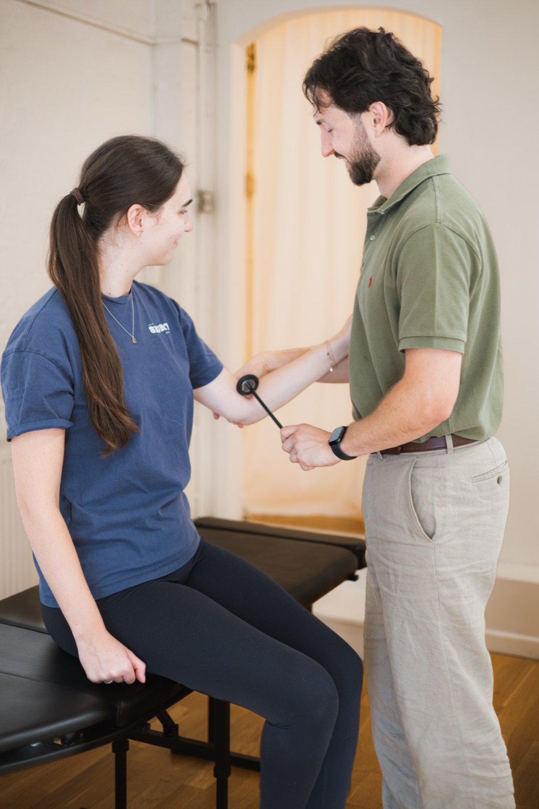 Tom testing a patient's reflexes at the elbow