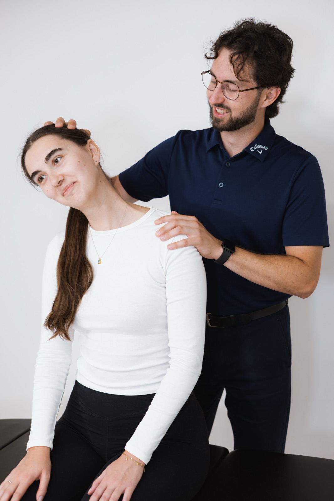 Tom with his hands on a patient's shoulders, checking how they sit